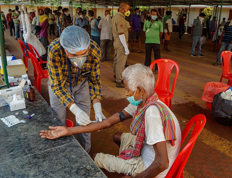 A health worker takes a sample of an elderly man for Rapid Test during the nationwide lockdown imposed in a bid to contain the spread of coronavirus, in Bhubaneswar, Monday, April 20, 2020. (PTI Photo) 
