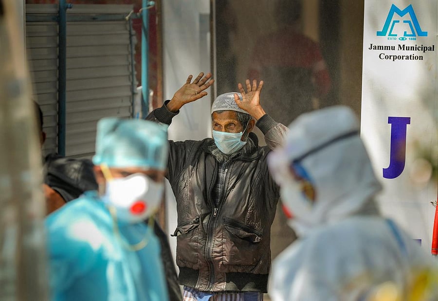 A Rohingya Muslim man prepares to walk through a full-body sanitization tunnel installed at COVID-19 dedicated Government Medical College hospital, in Jammu, Sunday, April 19, 2020. (PTI Photo)