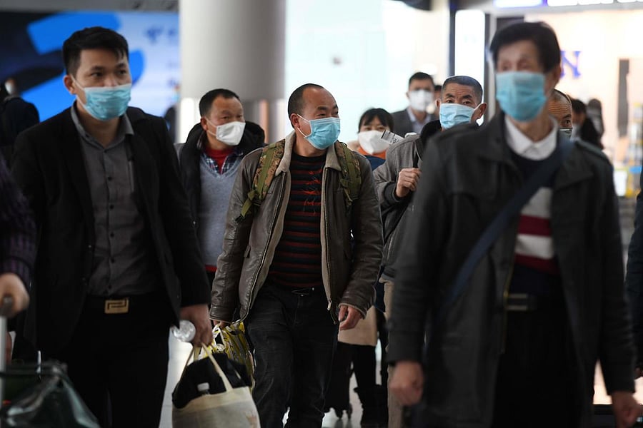 Passengers wear face masks as a preventive measure against the COVID-19 coronavirus as they arrive from a domestic flight at Beijing Capital Airport in Beijing on March 11, 2020. Credit: AFP Photo