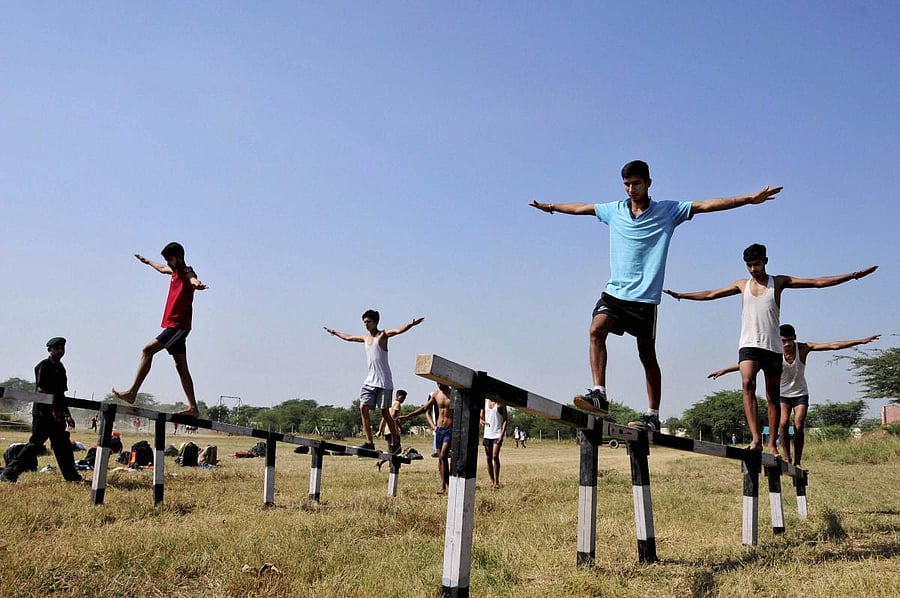 Amritsar: Candidates walk on balance beams during their physical fitness test at an Indian Army recruitment rally at Khasa near Amritsar on Thursday. PTI Photo