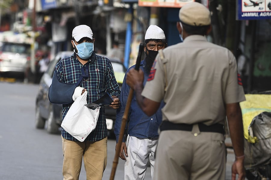 A police officer questions pedestrians at a checkpoint during a government-imposed nationwide lockdown as a preventive measure against the spread of the COVID-19. (Credit: AFP Photo)