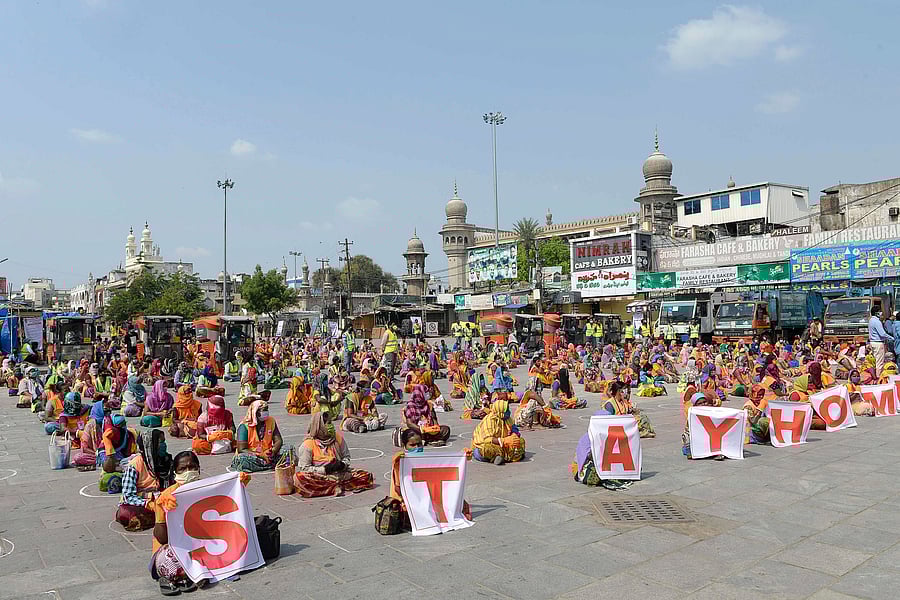 Greater Hyderabad Municipal Corporation (GHMC) workers sit maintaining social distance in an awareness programme in front of Mecca Masjid.(Credit: AFP Photo)