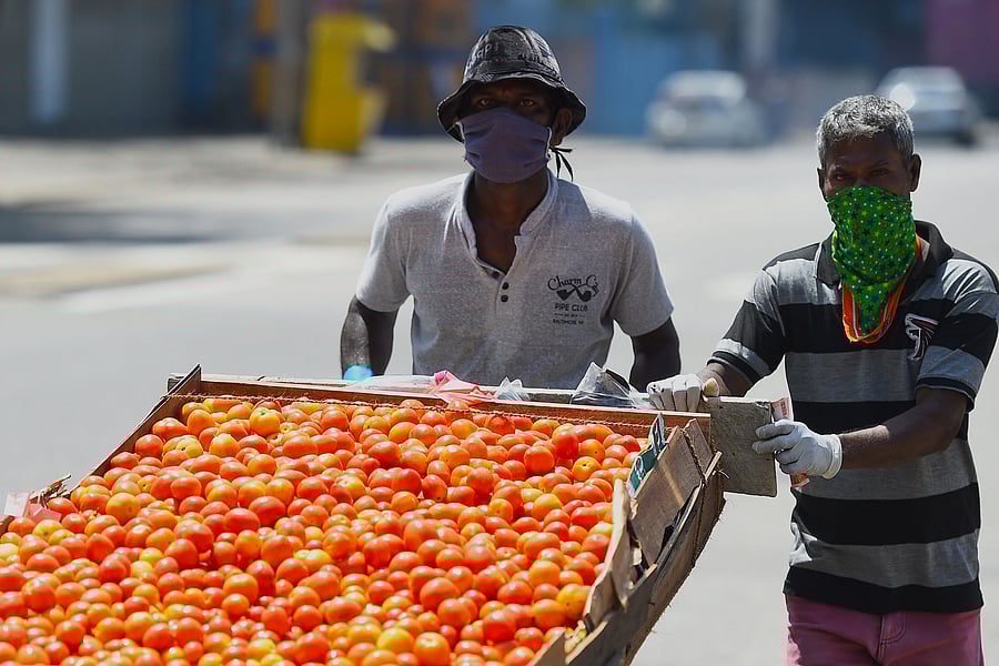 Vendors wearing facemasks look for customers along a deserted street in Colombo. (AFP Photo)