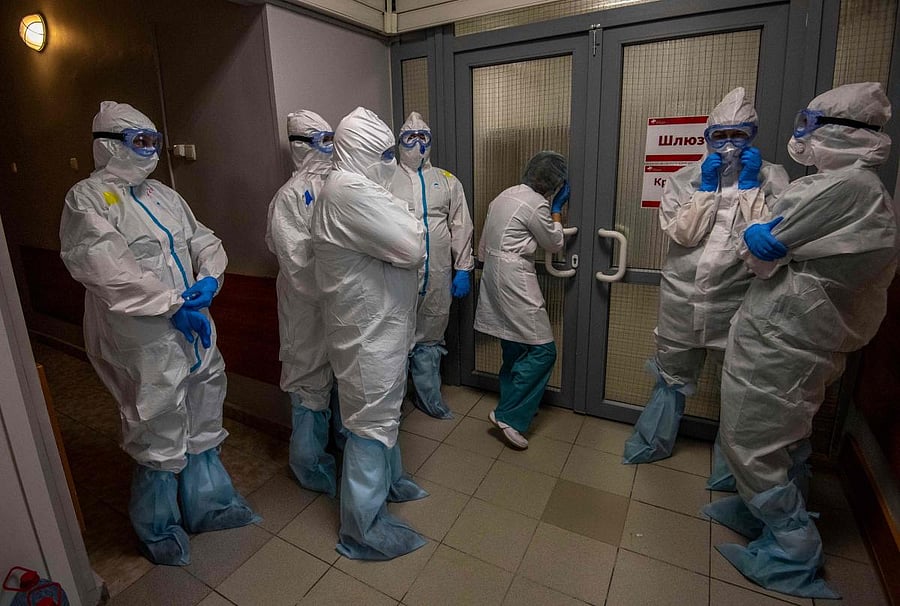 Medical workers wearing protective equipment wait in front of the gateway to enter the red zone to treat coronavirus patients (AFP Photo)