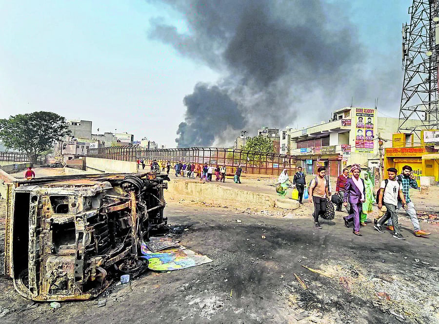 A bridegroom along with relatives heads for his wedding as they walk past Bhagirathi Vihar area of the riot-affected north east Delh. (PTI Photo)