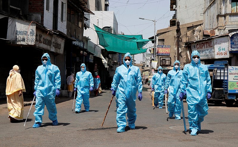 Policemen wearing protective suits patrol a street during the nationwide lockdown, in wake of the coronavirus pandemic, in Ahmedabad. (PTI Photo)