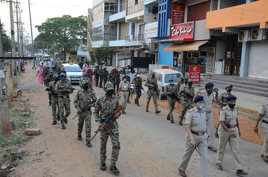 Police, officials and Asha workers take out a flag march in Tumakuru on Wednesday. DH Photo.