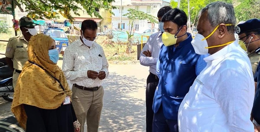 Medical Education Minister Dr K Sudhakar and District In-charge Minister S T Somashekar speak to Asha volunteer Sumaya Firdouse near her house at Aleem Nagar in Mysuru on Tuesday.