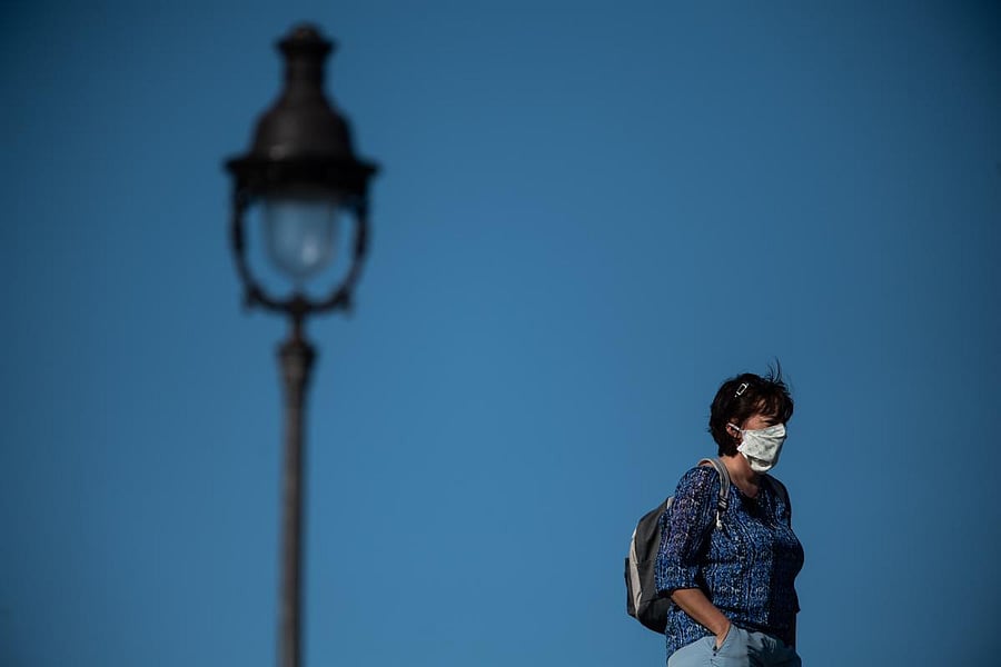 A woman wearing a protective facemask walks in Paris, on April 14, 2020, on the twenty-nineth day of a lockdown in France aimed at curbing the spread of the COVID-19 disease, caused by the novel coronavirus. Credit: AFP Photo