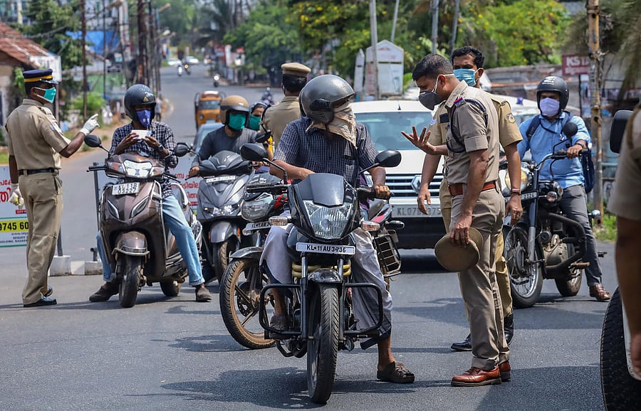 Police personnel question commuters for stepping out of their houses, during the nationwide lockdown to curb the spread of coronavirus, in Kozhikode, Thursday, April 23, 2020. (PTI Photo)