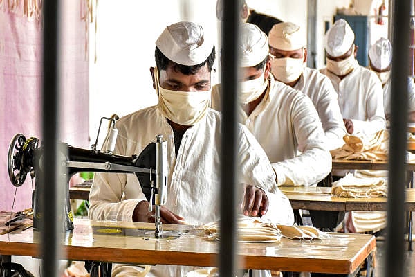 Inmates of Netaji Subhash Chandra Bose Central Jail wear protective masks in wake of coronavirus pandemic as they stitch face masks inside the jail, in Jabalpur. (PTI Photo)