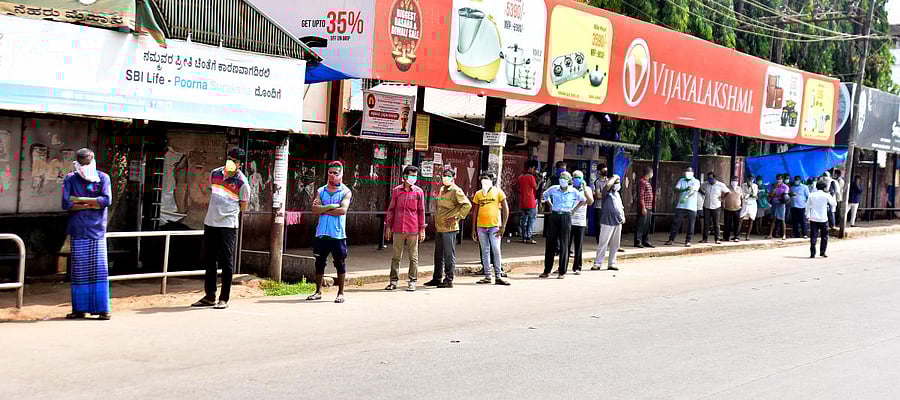 Customers wait for their turn, in the queue before a liquor outlet (not in picture), near Lady Goschen Hospital in Mangaluru on Monday.