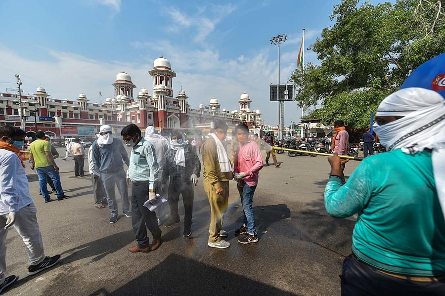 Migrants arriving by a special train from Nagpur being sanitised as they come out of the Charbagh railway station, amid COVID-19 lockdown in Lucknow. PTI
