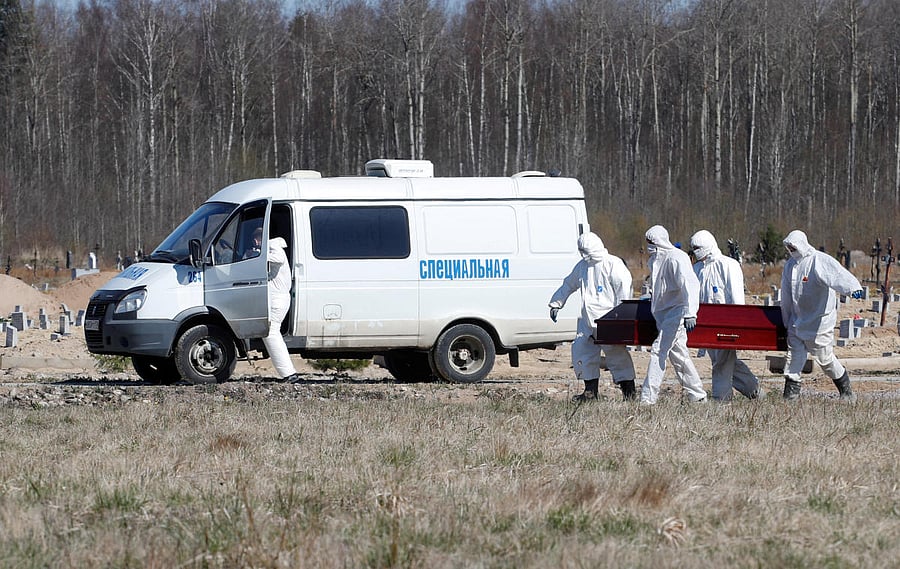 Grave diggers bury a coronavirus disease victim at a graveyard in Saint Petersburg. Reuters