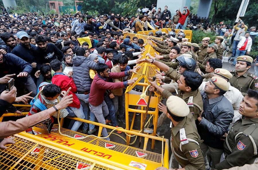 Police and protestors scuffle outside the Jamia Millia Islamia University during a protest against the Citizenship Amendment Bill in New Delhi. Credit: Reuters Photo