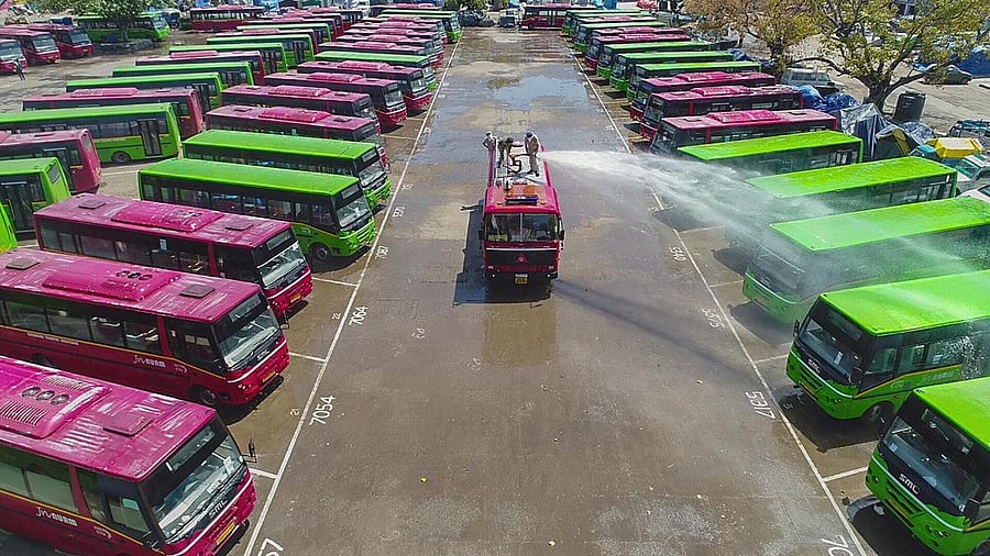 Firefighters spray disinfectant on buses on a road to prevent the spread of coronavirus in Chandigarh on Monday. PTI