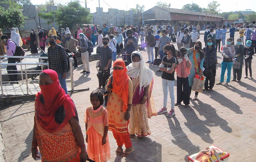 Migrants stand in queues to board busses (PTI Photo)