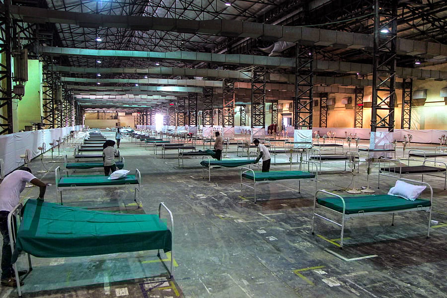 Workers prepare an quarantine center (isolation centre) for non-critical COVID-19 patients at the Bombay Exhibition Centre (NESCO Ground). (PTI Photo)