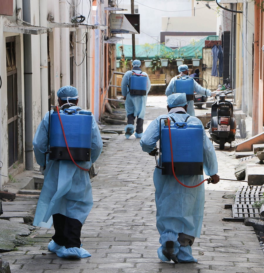 Health officials disinfect a street as part of measure to contain coronavirus pandemic, in Jammu. (PTI Photo)