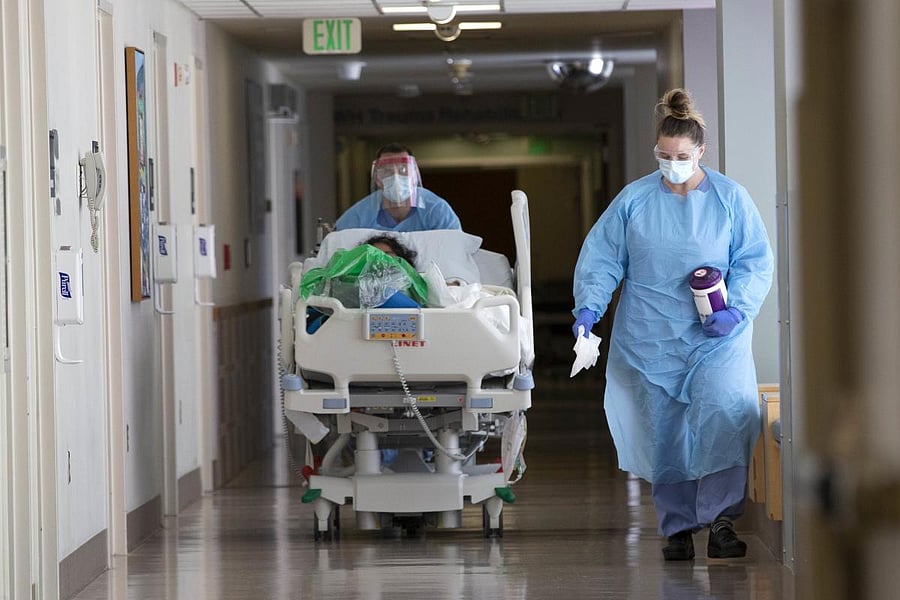  A nurse on infection control accompanies a patient being transferred from the ICU COVID unit to the acute care COVID unit  (AFP Photo)