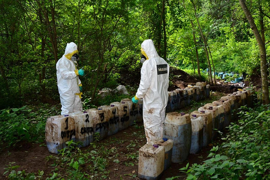 Forensic technicians of the Mexican Navy are seen at a clandestine drug processing laboratory where they seized 50 tons of methamphetamine discovered during an operation in the town of Alcoyonqui, on the outskirts of Culiacan, Mexico, in this handout phot