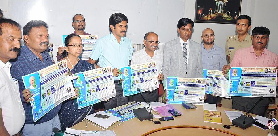 Deputy Commissioner Abhiram G Sankar releases awareness poster on Covid-19, at DC Office, in Mysuru on Friday. District Health Officer Dr R Venkatesh, Zilla Panchayat CEO K Jyothi, District Legal Services Authority (DLSA) Member- Secretary B P Devamane, M