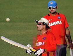 Sachin Tendulkar tosses the ball as teammate Virat Kohli(R) looks on during a training session at The Punjab Cricket Associaton (PCA) Stadium in Mohali on Sunday. AFP