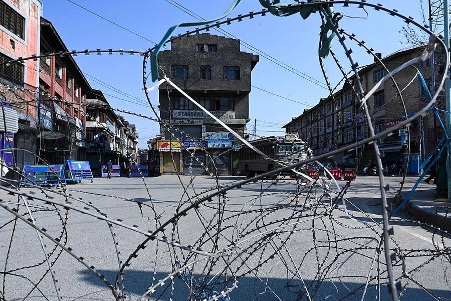 Soldiers stand guard at a roadblock following restrictions imposed as a preventive measure against the COVID-19 in Srinagar (AFP Photo)
