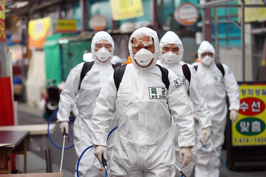 South Korean soldiers wearing protective gear spray disinfectant as part of preventive measures against the spread of the COVID-19 coronavirus, at a market in Daegu on March 2, 2020. Credit: AFP Photo