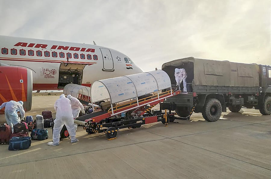 Workers unload the luggage of Indian nationals evacuated from Iran at Jaisalmer Military Station. Two Air India flights carrying over 230 Indians from coronavirus-hit Iran landed here on Sunday morning. (PTI Photo)