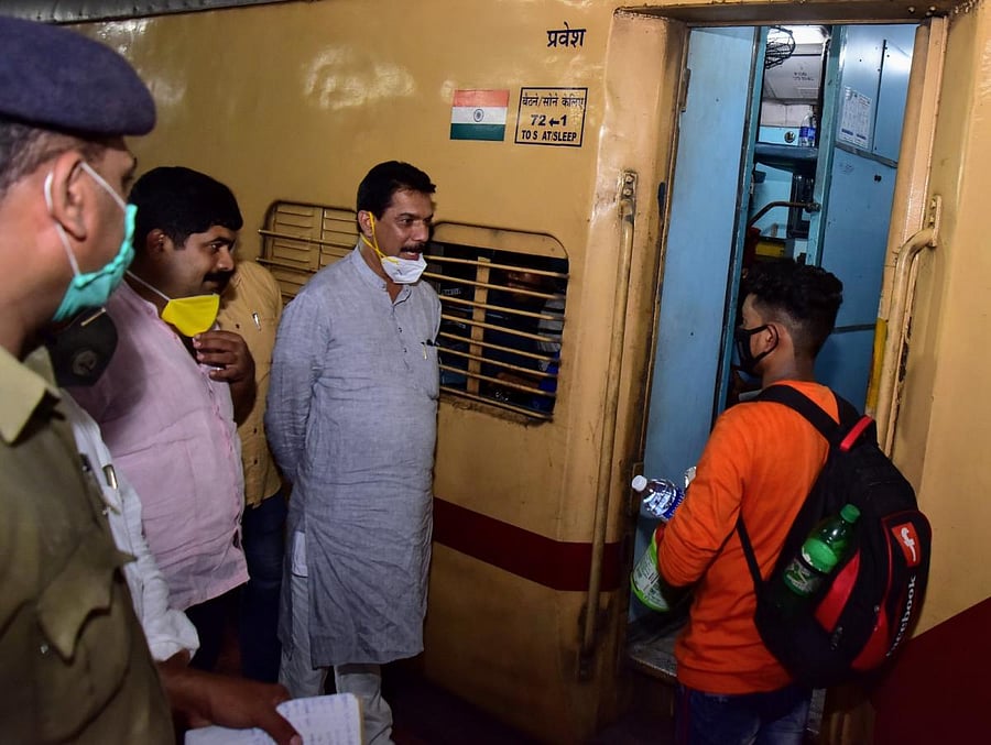 Dakshina Kannada MP Nalin Kumar Kateel interacts with a stranded labour who was boarding the train to North India, at Mangalore Junction Railway Station. DH Photo/Govindraju Javali