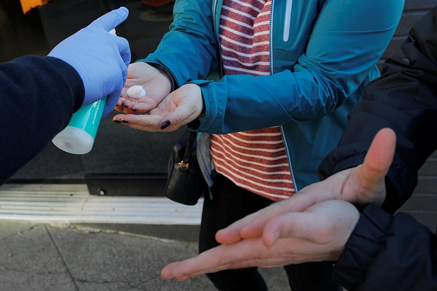 People are given hand sanitizer before being allowed to enter shop in US (Reuters Photo)