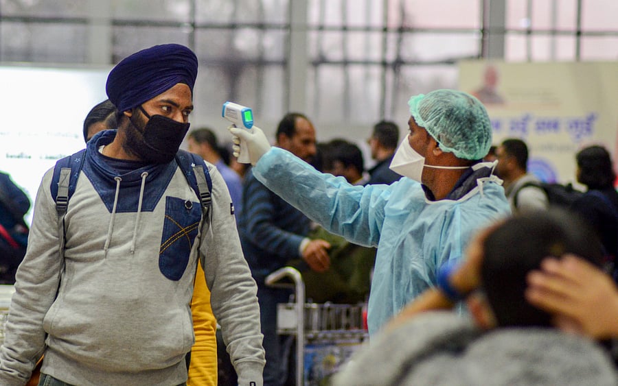 A medic official uses thermal screeing device on a passenger in the wake of deadly coronavirus, at an airport in Dibrugarh. (PTI Photo)