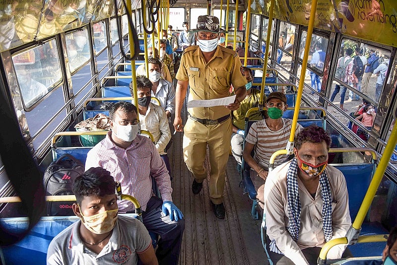 Migrants board NMMT buses at Turbhe MIDC Police Station to reach their native state Madhya Pradesh, during a nationwide lockdown in the wake of coronavirus pandemic. (PTI Photo)