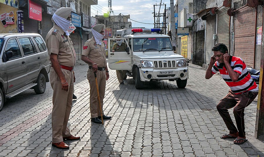 Police personnel punish an offender for flouting guidelines on lockdown, put in place in the view of coronavirus pandemic, in Patiala. (Credit: PTI Photo)