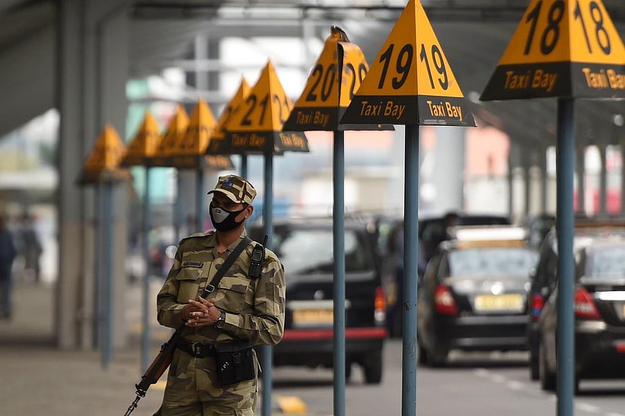 A security personnel wearing a facemask amid concerns over the spread of the COVID-19 novel coronavirus, stands guard outside at the Indira Gandhi International Airport in New Delhi on March 16, 2020. (Photo by AFP)