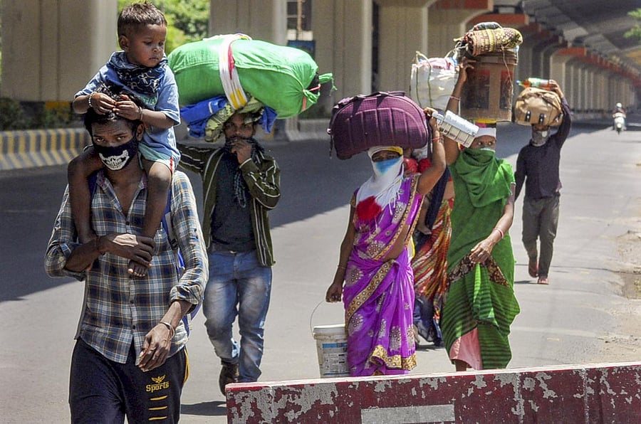  Migrant workers from Balaghat (MP) carry their belongings as they walk towards their native places, during the nationwide lockdown to curb the spread of coronavirus, in Nagpur. Credit: PTI Photo
