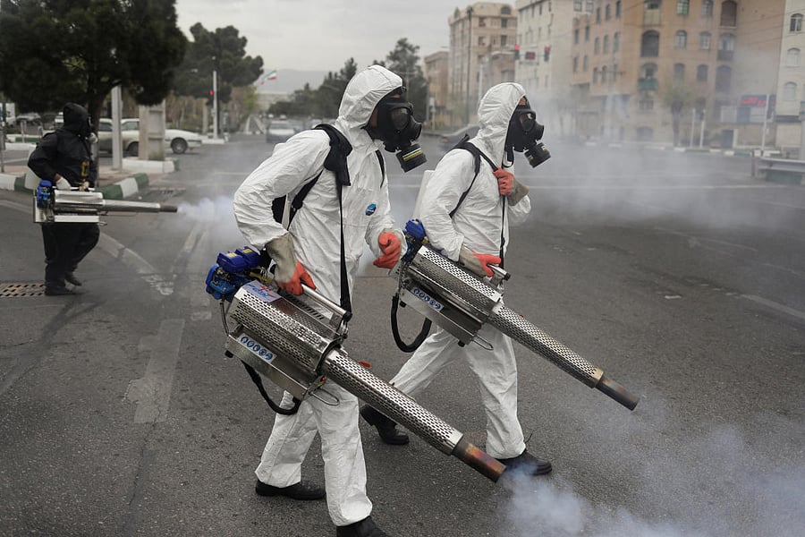 Members of firefighters wear protective face masks, amid fear of coronavirus disease, as they disinfect the streets. (Reuters Photo)