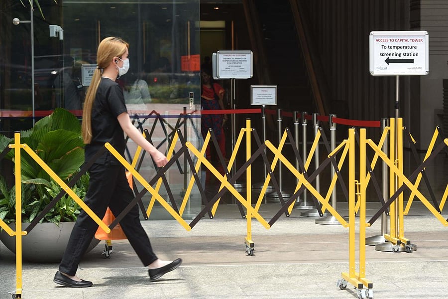 A woman wearing a face mask approaches a temperature screening area of an office building as a preventive measure against the coronavirus. AFP