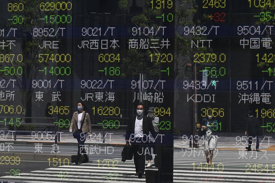 Pedestrians are seen reflected in a quotation board displaying stock prices on the Tokyo Stock Exchange in Tokyo on May 7, 2020. Credit: AFP Photo