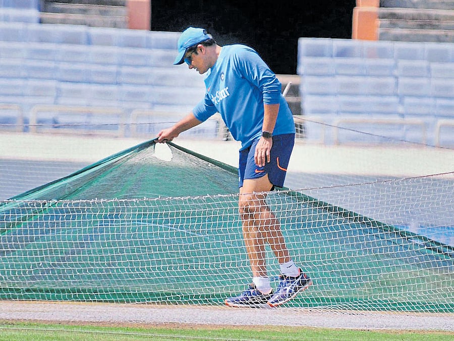 peekaboo!: India's Head Coach Anil Kumble checks the pitch at the JIRS Stadium in Ranchi on Tuesday. pti