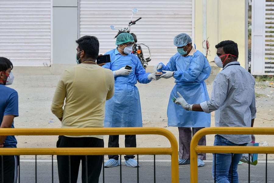Paramedics, government municipal and police officials stand outside a private hotel as they plan the safe evacuation and hospitalisation of a suspected positive COVID-19 (AFP Photo)