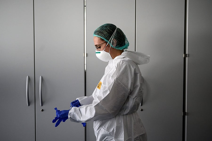 A nurse puts on her Personal Protective Equipment (PPE) before starting to work on the preparation of the Intensive care unit in the new COVID-19 Hospital in Verduno, near Alba, Northwestern Italy. (Credit: AFP)
