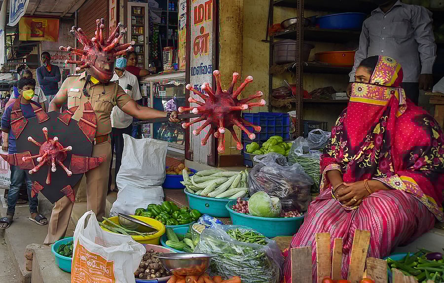 A policeman wearing a coronavirus-themed outfit walks at a market to raise awareness about coronavirus. (PTI Photo)