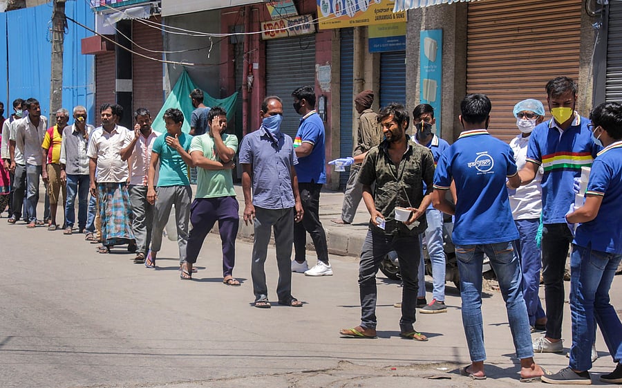 Volunteers distribute food packs to people during a nationwide lockdown in the wake of novel coronavirus pandemic, in Bengaluru. (PTI Photo)