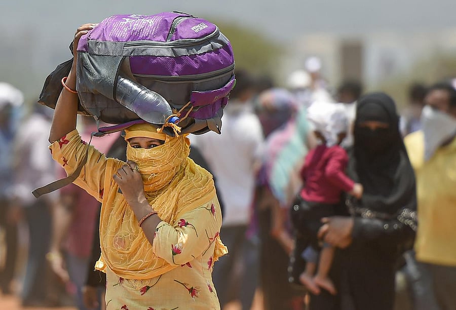Mumbai: A migrant with her belongings arrives to board a bus departing for railway terminus during the ongoing nationwide COVID-19 lockdown, at Wadala in Mumbai, Wednesday, May 13, 2020. (PTI Photo/Kunal Patil)(PTI13-05-2020_000133A)
