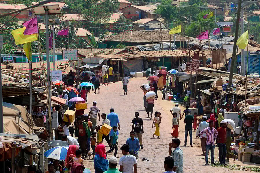 Rohingya refugees, without wearing any mask or any other safty gear as a preventive measure against the COVID-19 novel coronavirus, gather along a market area in Kutupalong refugee camp in Ukhia, (Credit: AFP)