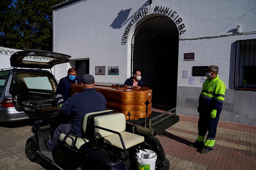 Municipal workers transfer a coffin to the cementery in Tomelloso. (Credit: AFP)