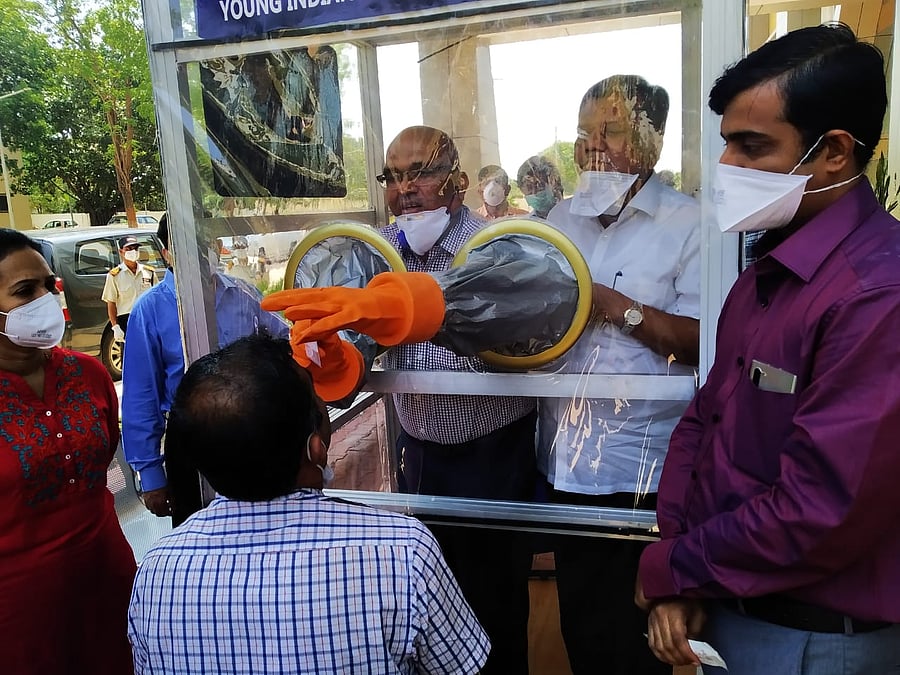 Industries Minister Jagadish Shettar observes throat swab collection demonstration using the swab collection box donated by Young Indians and Ladies Circle India, at KIMS in Hubballi on Wednesday. (Credi: DH Photo)