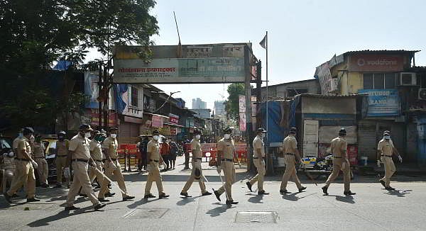 Police personnel patrol at Jijamata Nagar in Worli where several Covid-19 positive cases were found following the coronavira pandemic, in Mumbai. (Credit: PTI Photo)